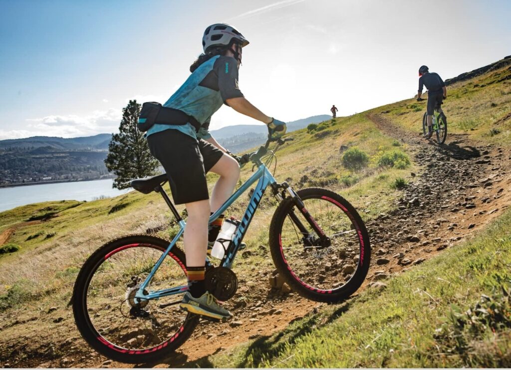 Mountain bikes under 500 riding uphill on a rocky trail, showing a budget-friendly hardtail mountain bike being used for recreational off-road cycling in a scenic outdoor landscape.