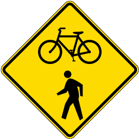 Bicycle crossing warning sign at a road intersection highlighting a high-risk conflict zone for road signs for cyclists