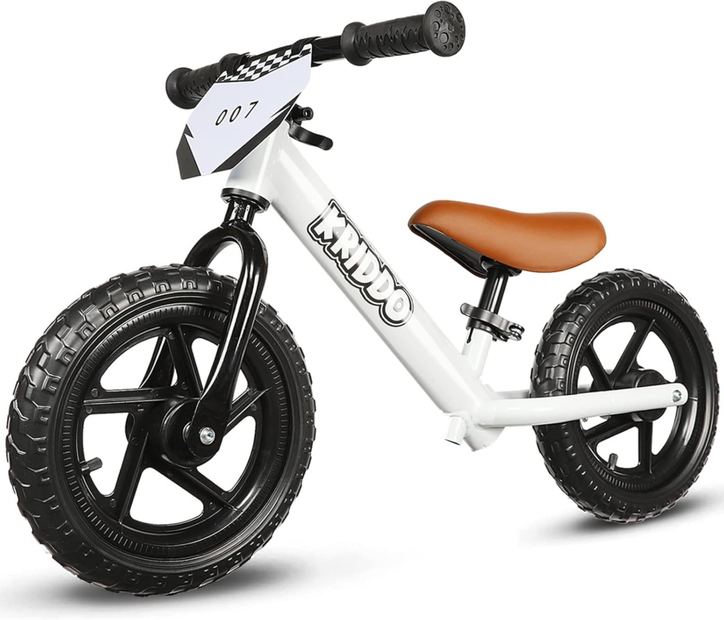 Best Bikes for 2 Year Olds: white toddler balance bike with wide tires and brown seat designed to help young children learn balance before pedaling